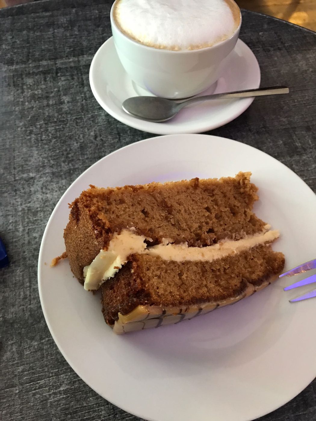 A slice of carrot cake with a cappuccino
